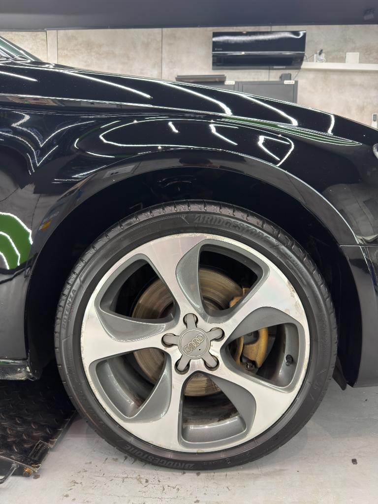 Glossy black Audi bodywork and wheel after detailing